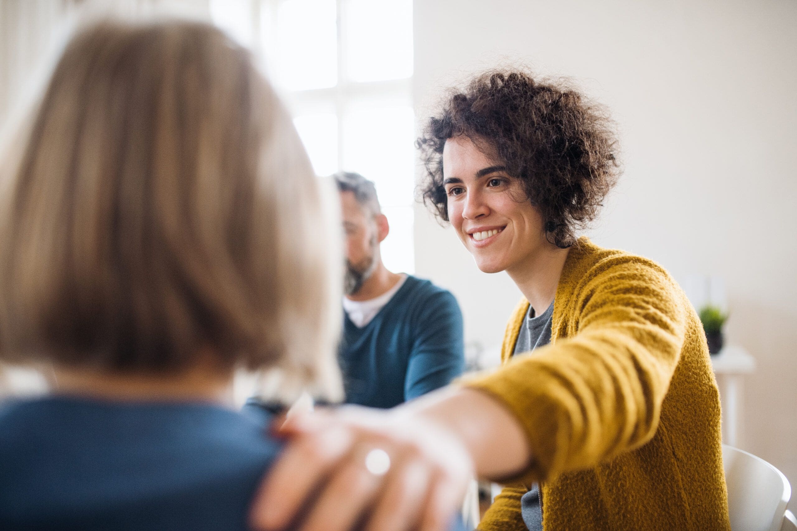 A compassionate counselor offering support during a group therapy session, symbolizing the journey of Detoxing from Methamphetamines (Meth).